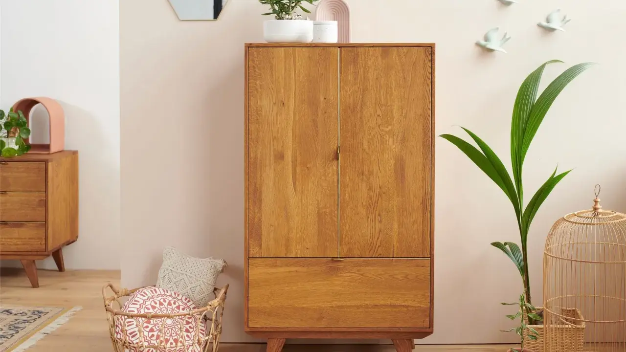 Un buffet haut en bois de chêne, avec un tiroir et deux portes, orné de plantes et d'objets décoratifs.