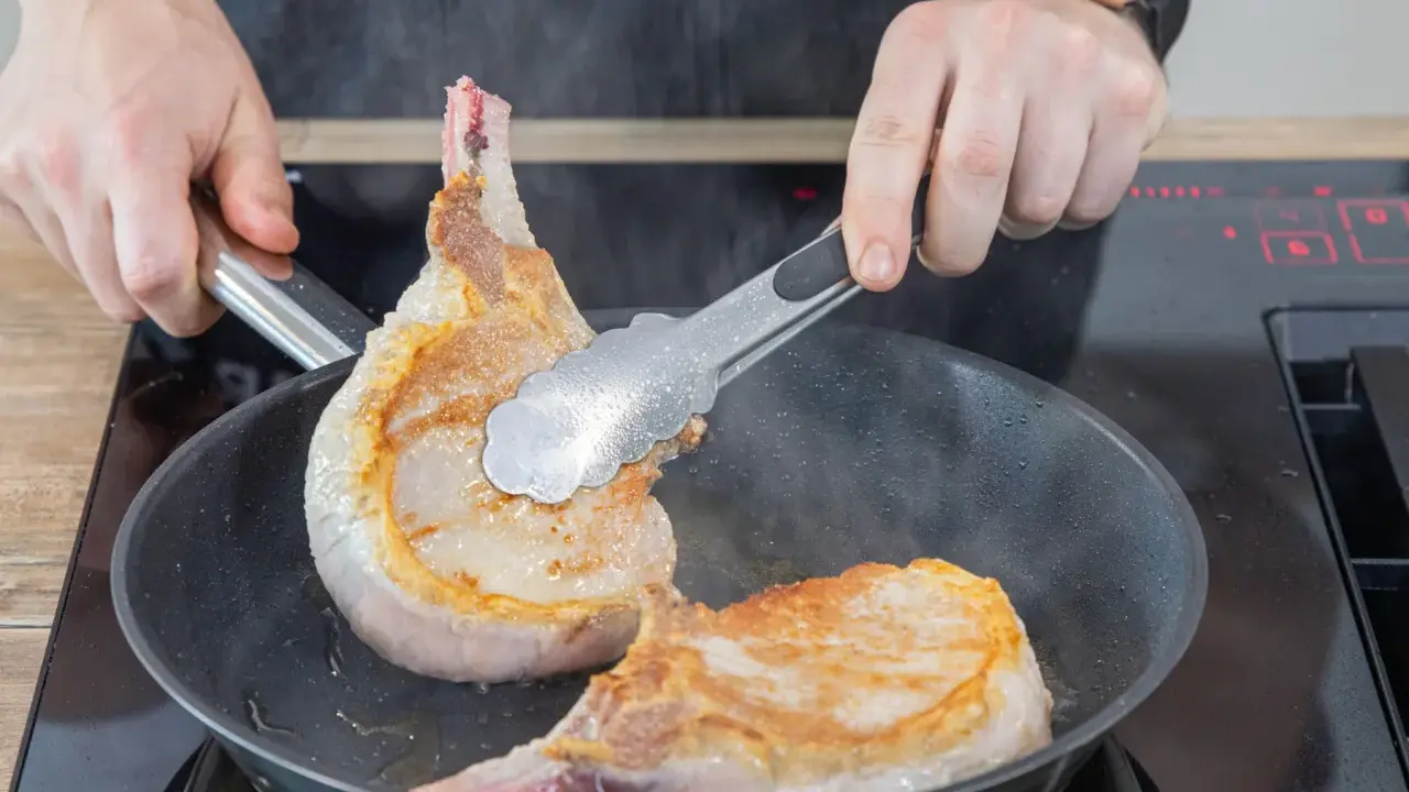 Zwei saftige Koteletts braten in der Pfanne. Perfekt für leckere Kotelett Rezepte.