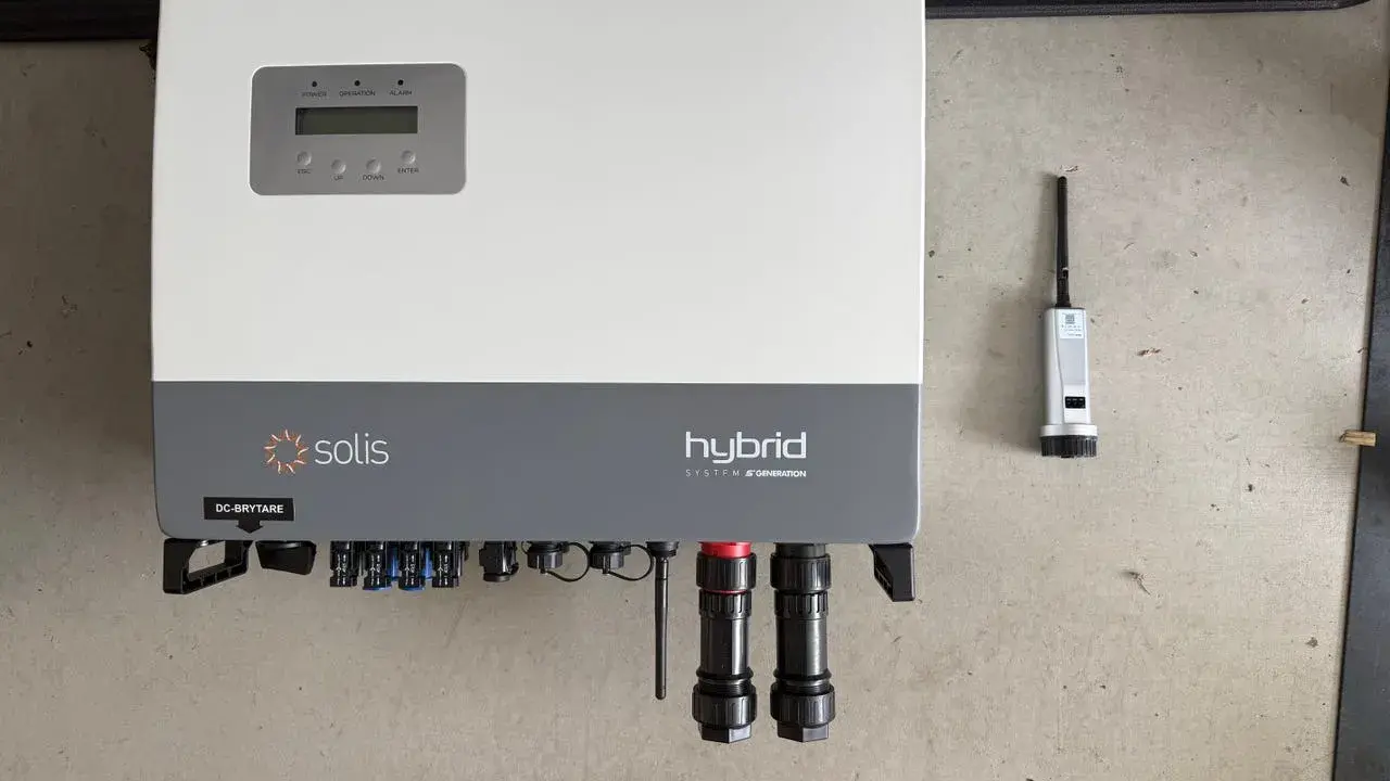 Solis hybrid växelriktare med display och anslutningar. Bredvid syns en liten antenn.