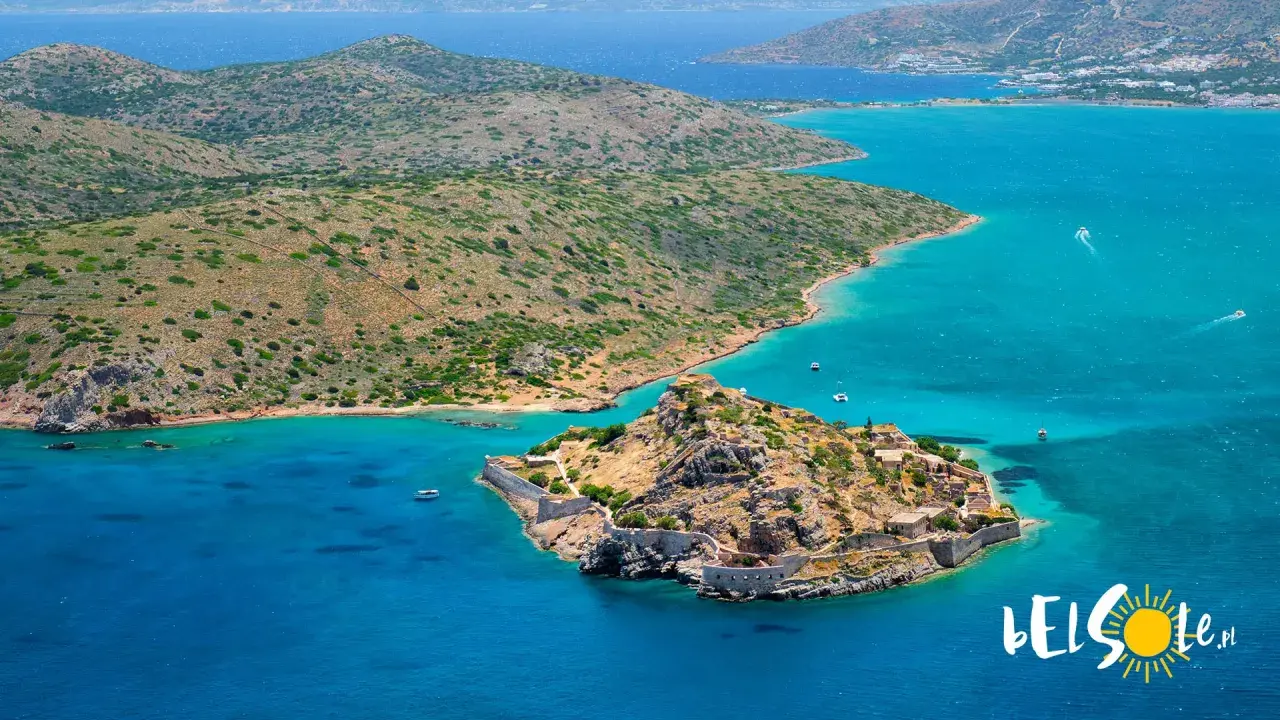 Kreta, lipiec: słoneczna pogoda i turkusowe morze otaczają skalistą wyspę z ruinami fortecy.