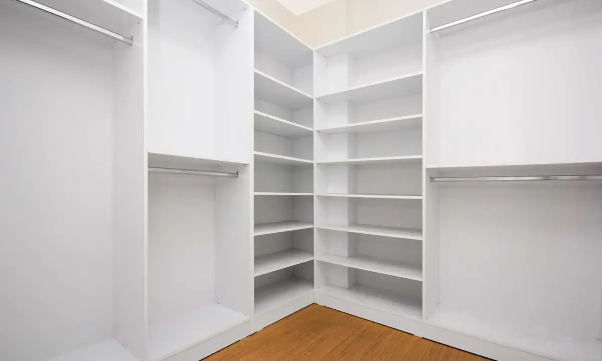 Ideas para vestidor cerrado: estanterías blancas y barras para colgar ropa, creando un espacio organizado y funcional.