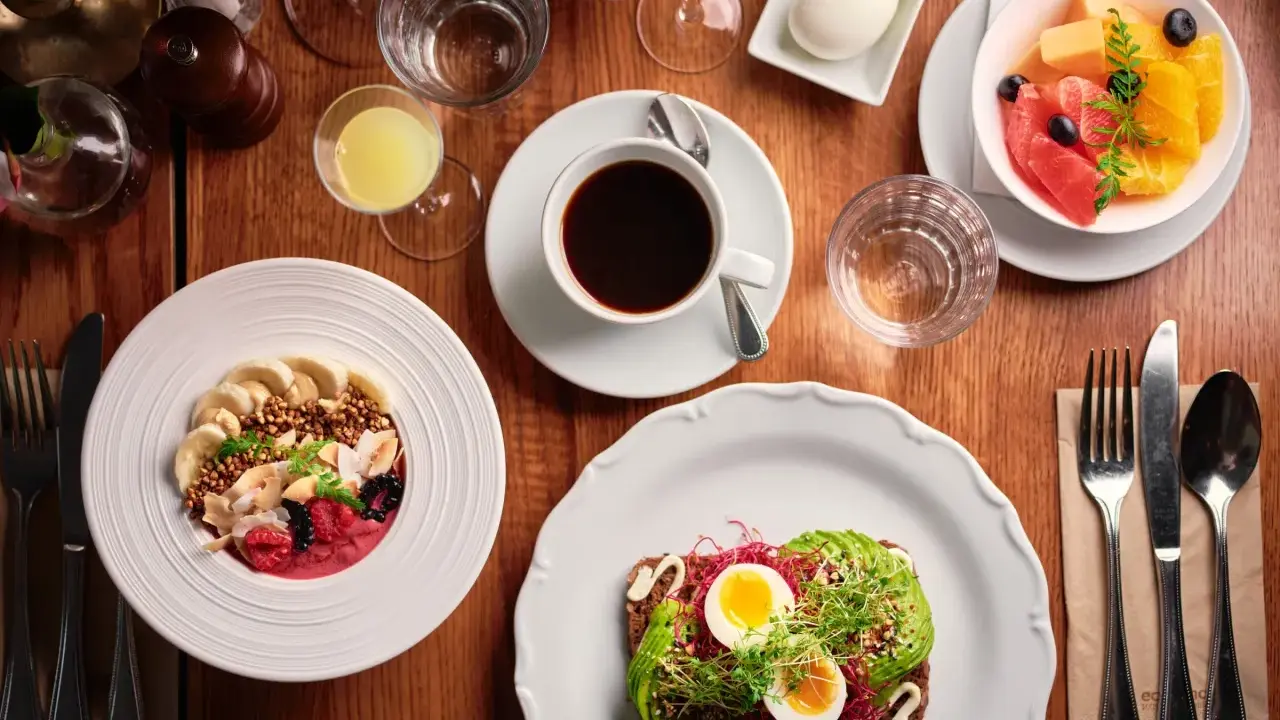 En härlig frukost i Stockholm med en smoothie bowl, avokadotoast, frukt och kaffe.