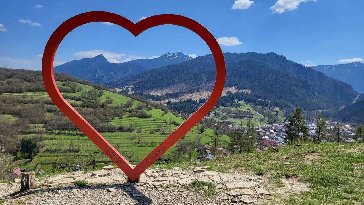 Czerwone serce na tle górskiej panoramy Słowacji. Widok z wieży widokowej na malowniczą dolinę i miasteczko.
