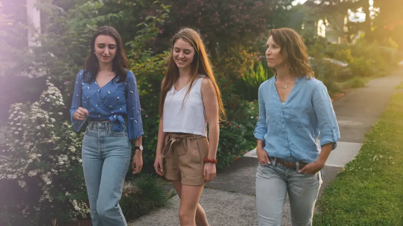 Trois femmes profitent d'une promenade paisible, savourant le moment présent. Une scène de slow tech, où la connexion humaine prime sur le numérique.