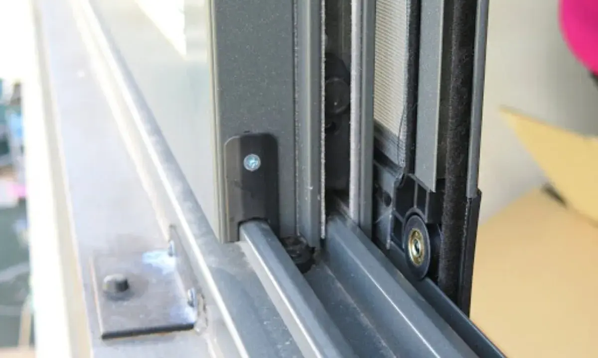 Detalle de cómo hacer una mosquitera corredera: el marco de aluminio y la malla en un riel.