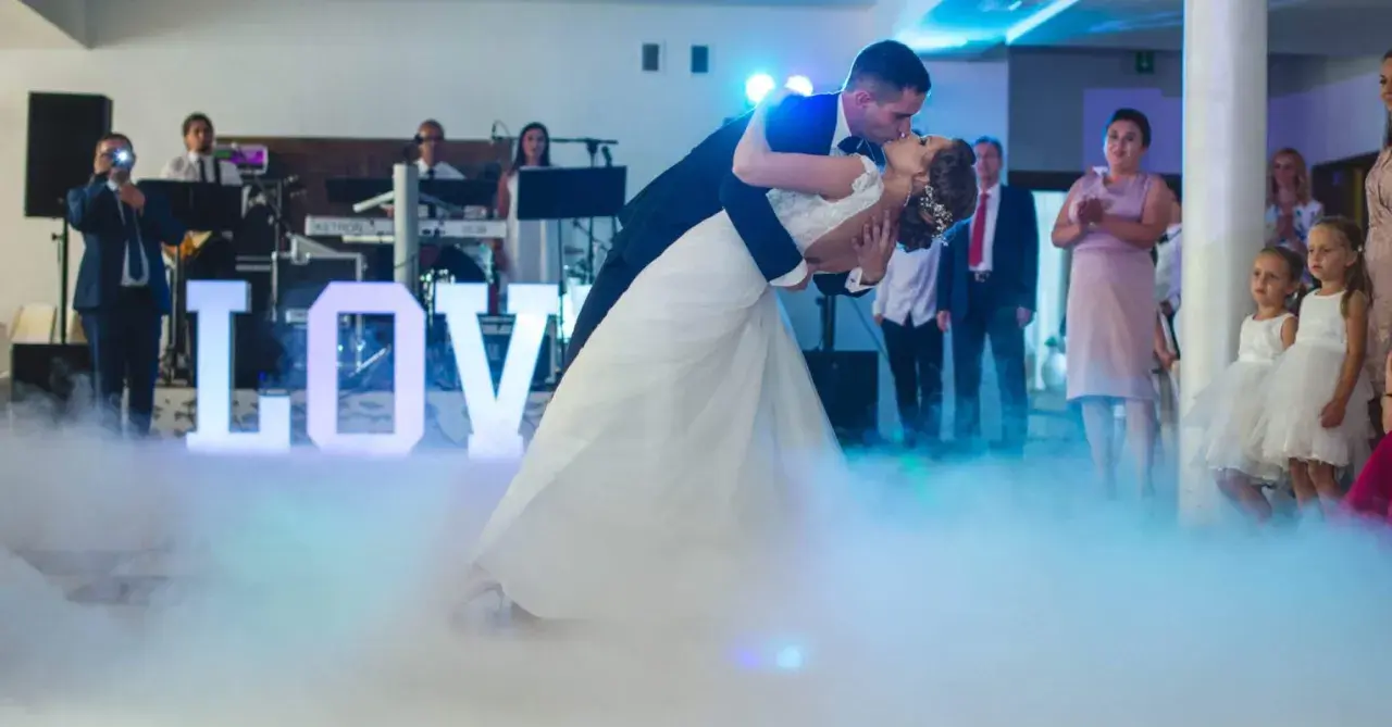 Para młoda tańczy do muzyki na weselu, otoczona mgłą i literami "LOVE". To jak scena z najsłynniejszych baletów.