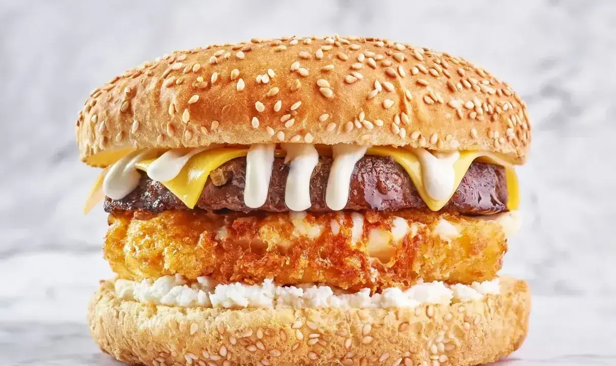 Pyszny burger drwala przepis: soczysty kotlet, chrupiące panierowane jajko, ser i biały sos na sezamowej bułce.