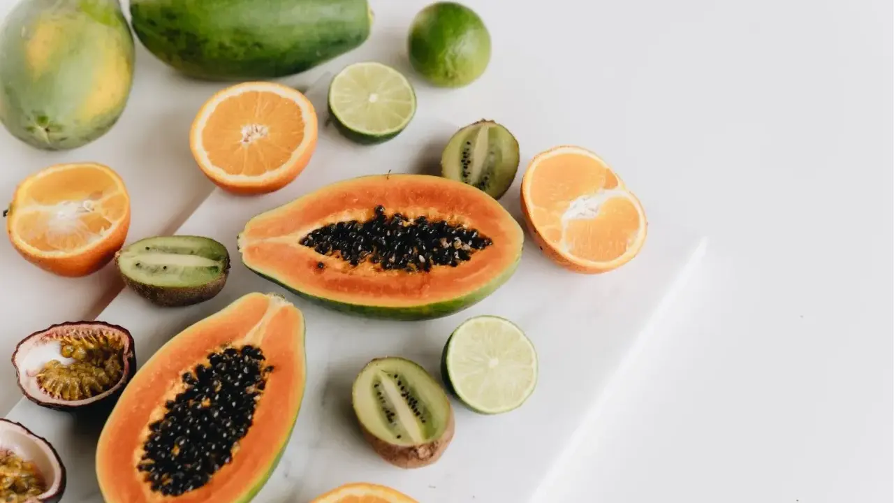 Kolorowe owoce: papaja, kiwi, pomarańcze, limonki i marakuja. Czy owoce tuczą? Te na zdjęciu wyglądają zdrowo i pysznie!