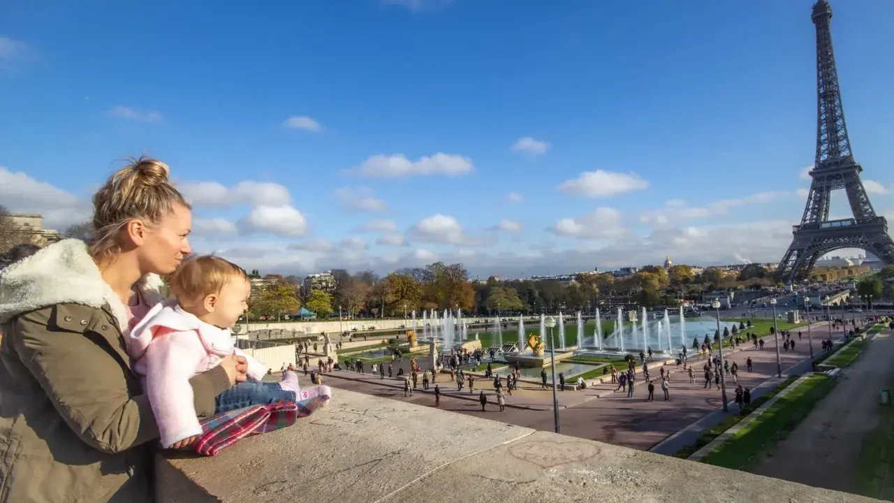 Madre y bebé disfrutan de la Torre Eiffel y las fuentes en Francia con niños.