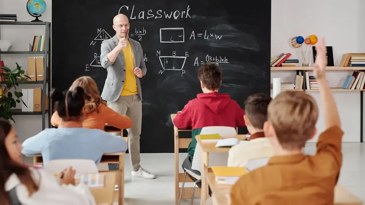 Nauczyciel tłumaczy matematykę, a uczeń podnosi rękę. Ciekawe, ile zarabia nauczyciel za taką pracę?