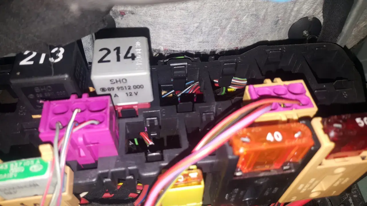 Skrzynka bezpieczników Audi A4 B5 z widocznymi przekaźnikami i kolorowymi bezpiecznikami.