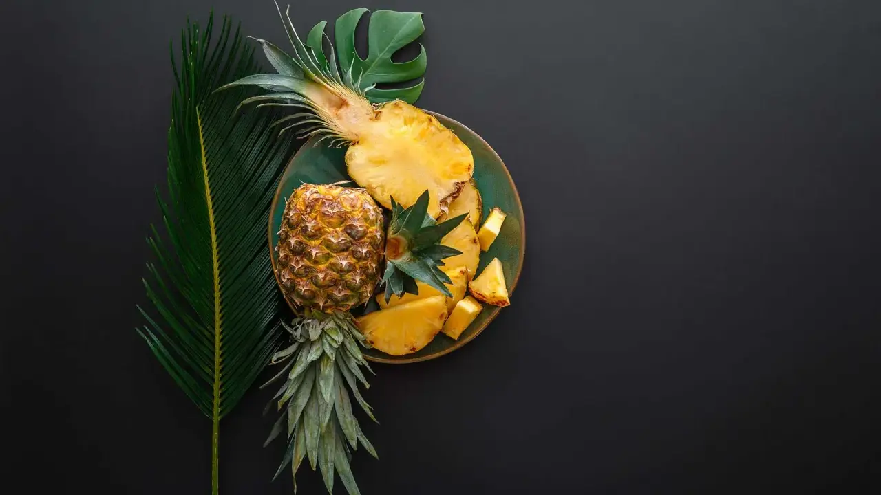 Ananas na talerzu, obok liści. Czy wiesz, że bromelaina co to za enzym?
