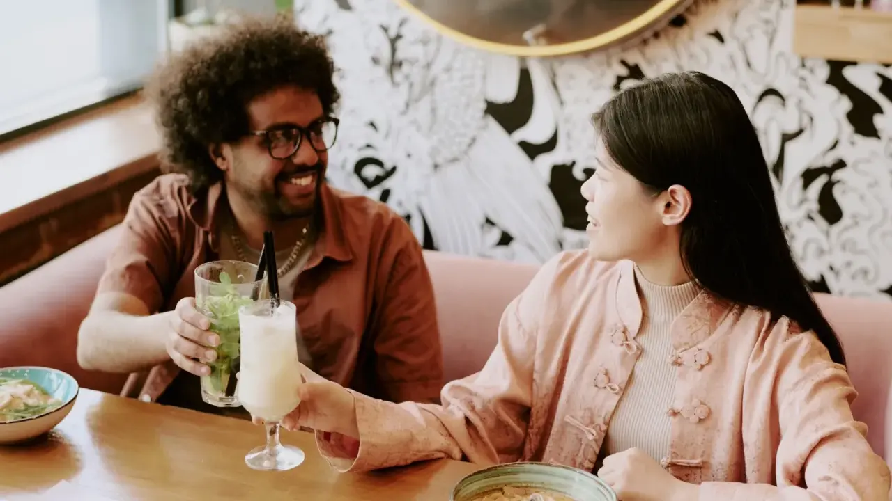 Para, pijąc drinki, cieszy się wspólnym posiłkiem w jednej z romantycznych miejsc w Warszawie.