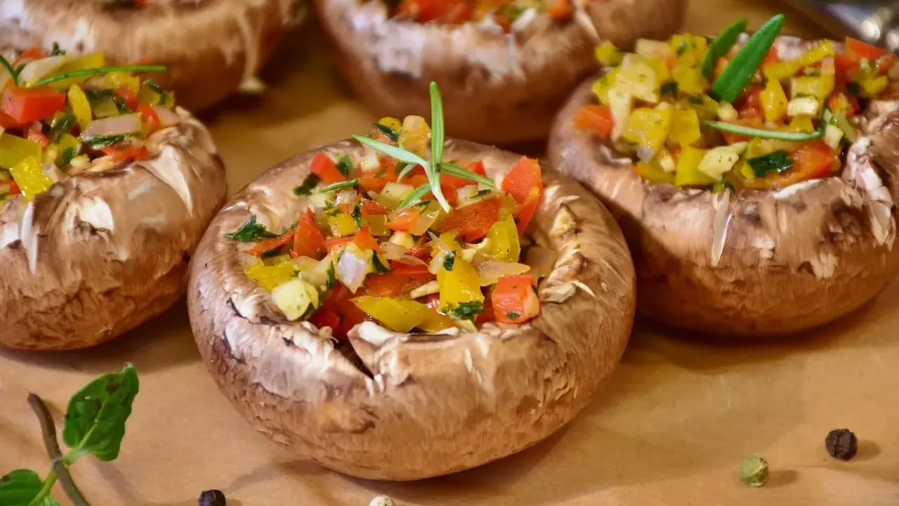 Champignons farcis aux poivrons colorés et herbes fraîches, prêts à être dégustés.