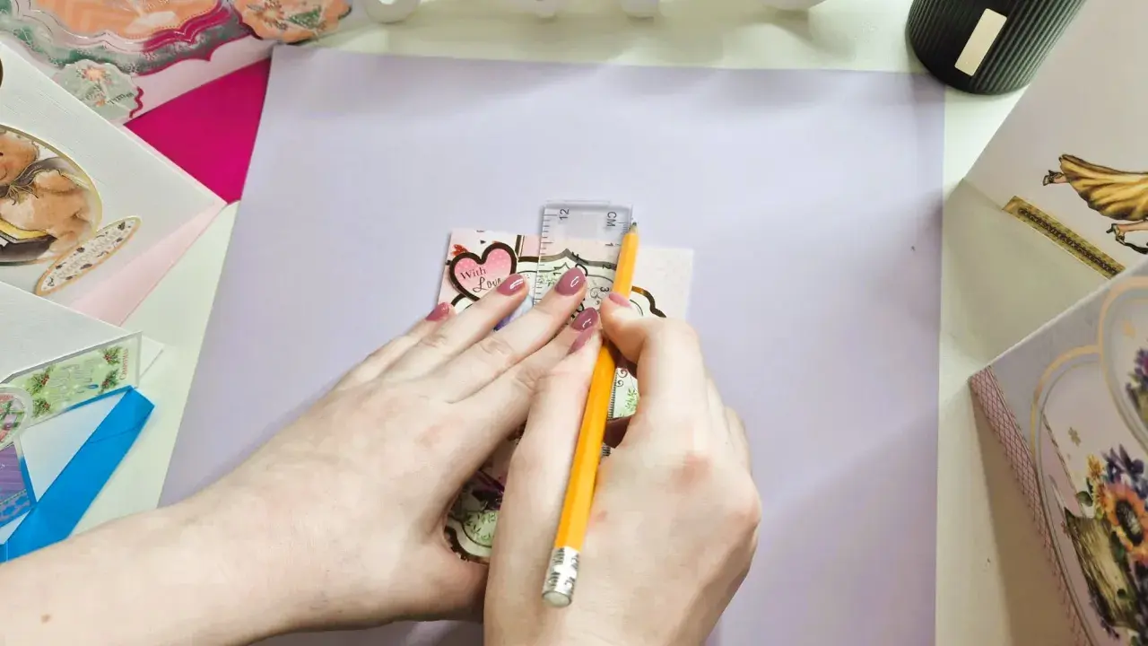 Manos midiendo con regla y lápiz para crear un sobre de papel A4.