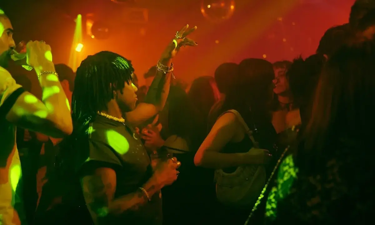 Persone che ballano in un locale notturno, luci stroboscopiche e musica alta: il vero clubbing significato.