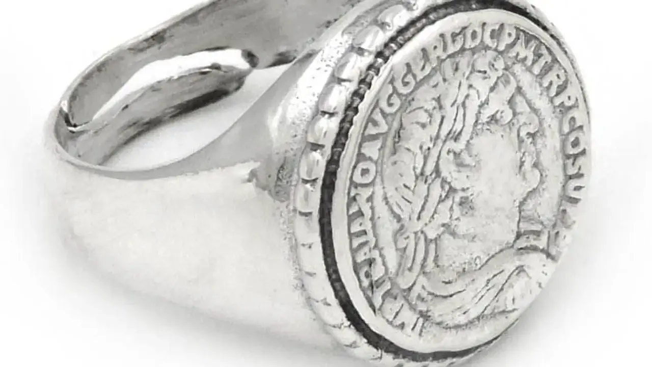 Anello in argento con moneta antica incisa, un pezzo unico che porta con sé storie di epoche passate.