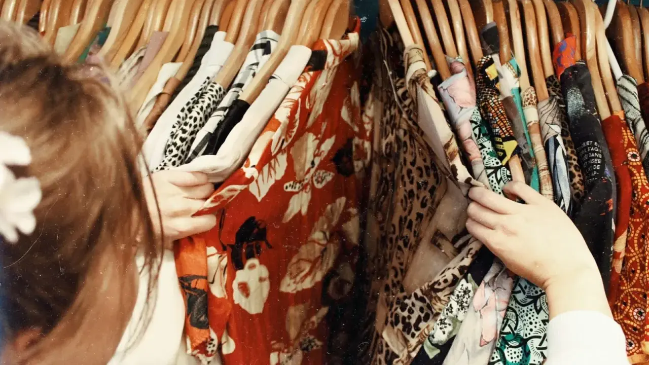 En person letar efter vilken stil har jag bland färgglada kläder med mönster som leopard och blommor.