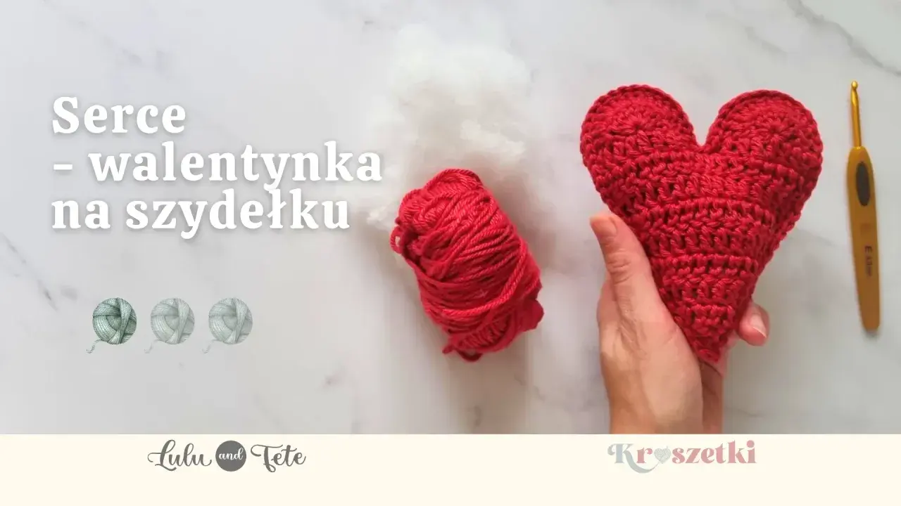 Czerwone serce na szydełku, gotowe na walentynki. Obok kłębek czerwonej włóczki i białe wypełnienie.