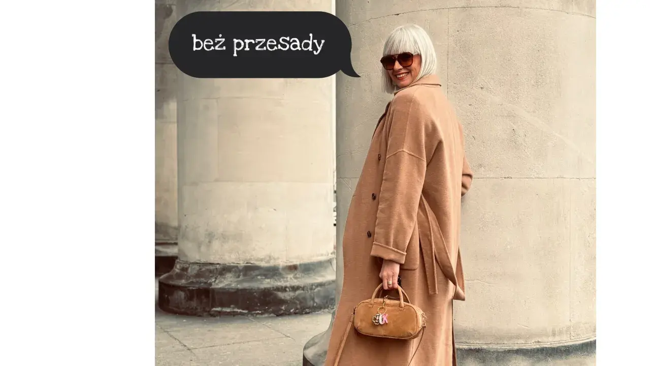 Kobieta w beżowym płaszczu i okularach przeciwsłonecznych, z małą torebką, prezentuje seksowny ubiór na co dzień.