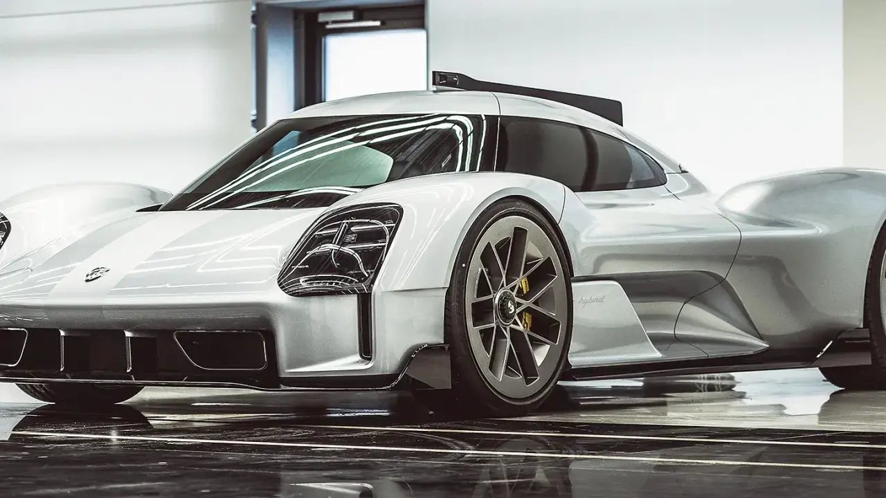 Silberner Porsche Hypercar mit aggressiven Linien und auffälligen Scheinwerfern, bereit für die Rennstrecke.