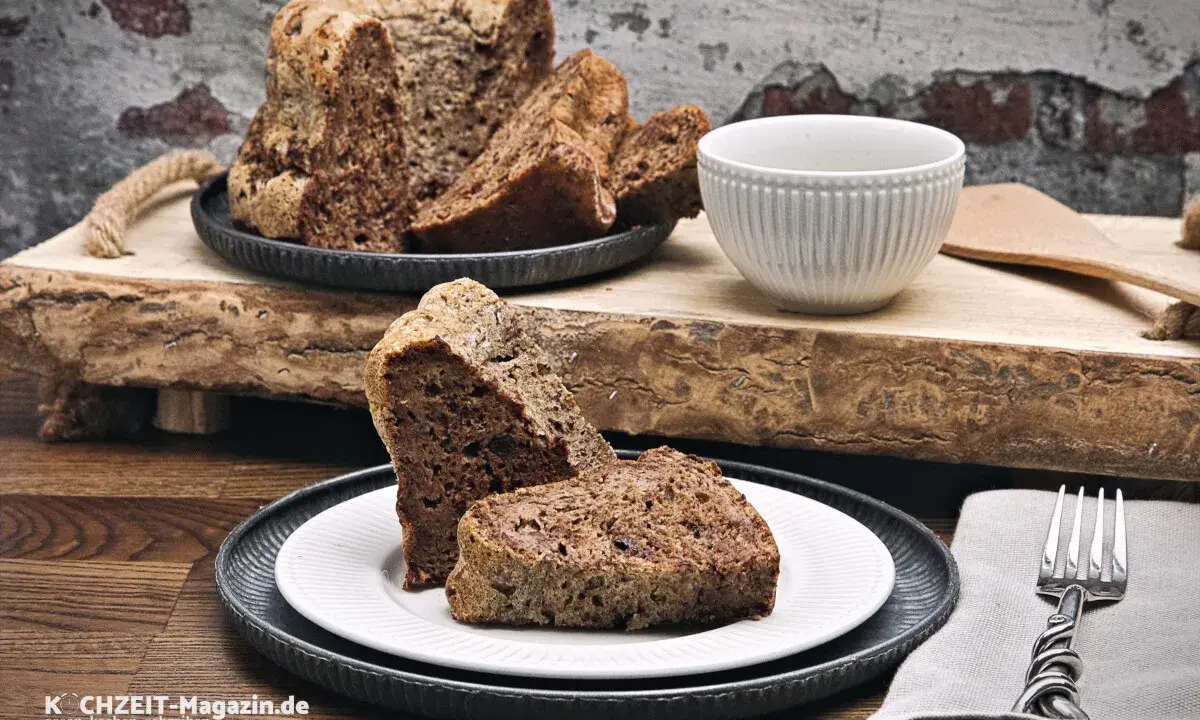 Saftiger **Diabetiker Kuchen** auf rustikalem Holzbrett, serviert auf Tellern mit Gabel.