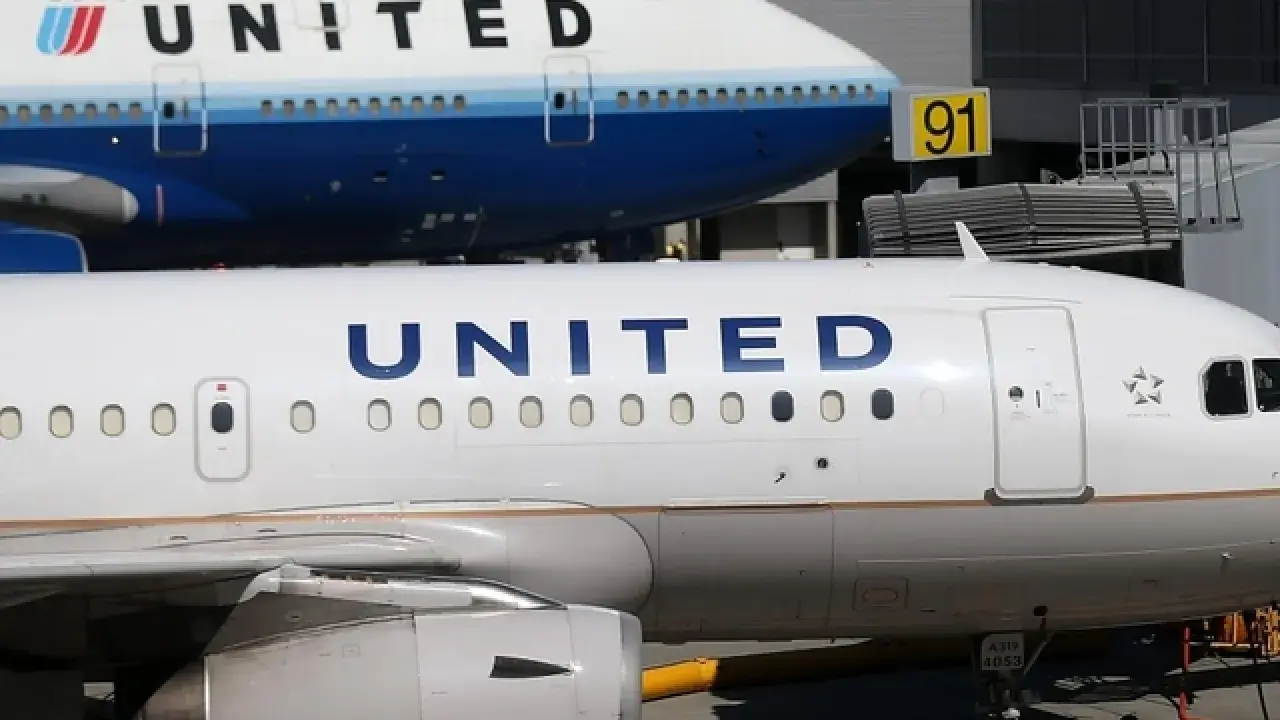 Dwa samoloty United Airlines na płycie lotniska. Jeden z nich to Boeing 747, drugi to mniejszy samolot. W tle widać budynek terminala.