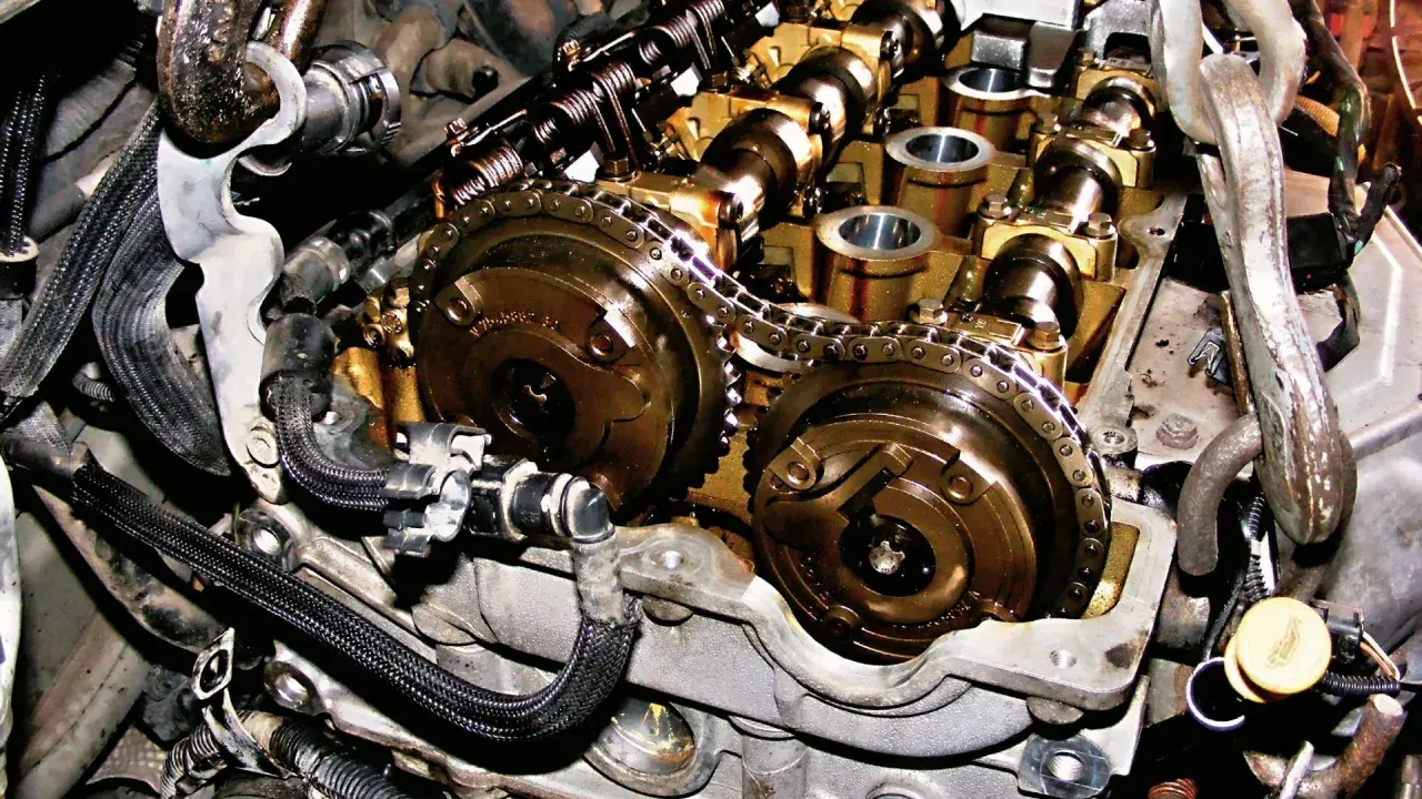 Wnętrze silnika Peugeot 1.6 THP z widocznym łańcuchem rozrządu i wałkami.