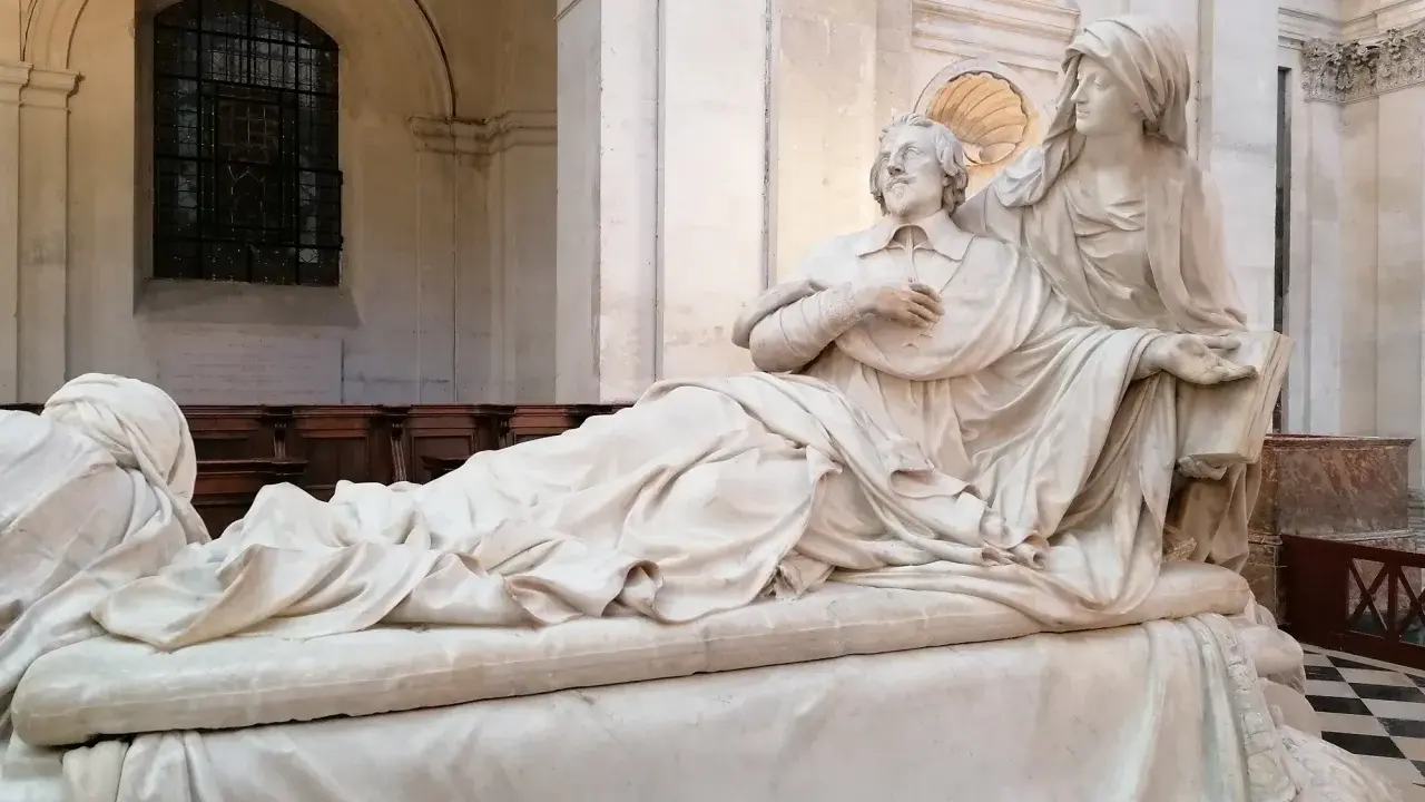 Pomnik kardynała Richelieu. Ciekawostki o jego życiu i wpływach. Rzeźba przedstawia go w otoczeniu alegorycznych postaci.