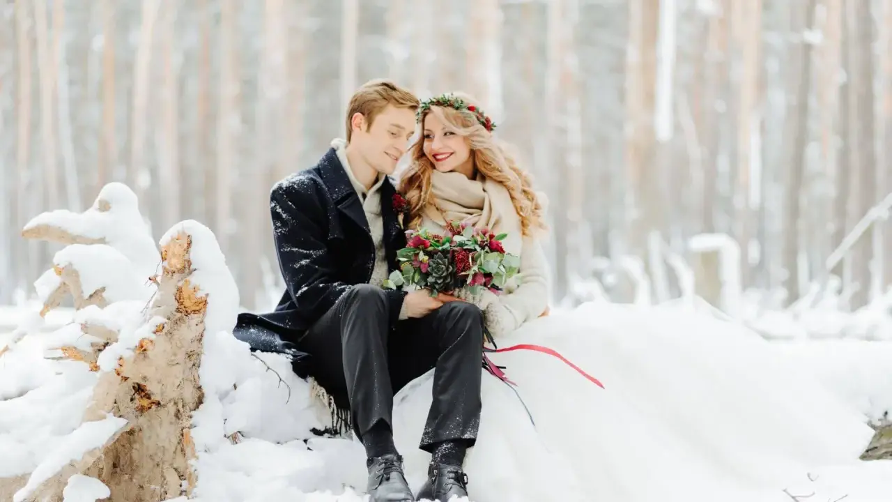 Para młoda w zimowej scenerii. Romantyczny ślub w styczniu w otoczeniu śniegu i drzew.