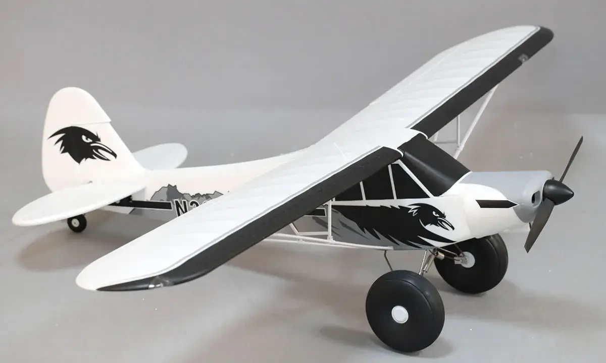 Modellflugzeug Piper PA-18 mit Adler-Design, bereit zum Abheben.