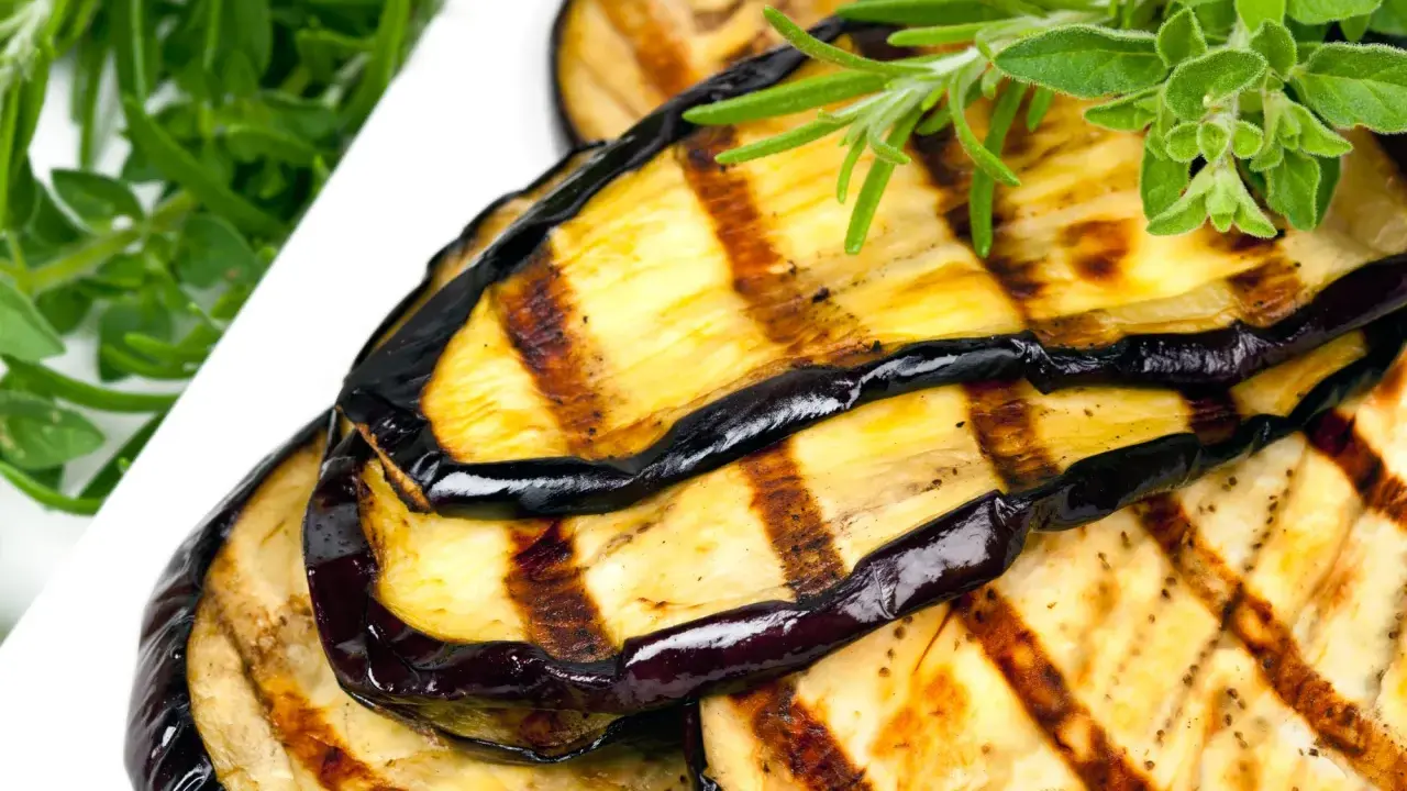 Gegrillte Auberginenscheiben mit Kräutern garniert. Perfekt für ein leckeres Aubergine einlegen.
