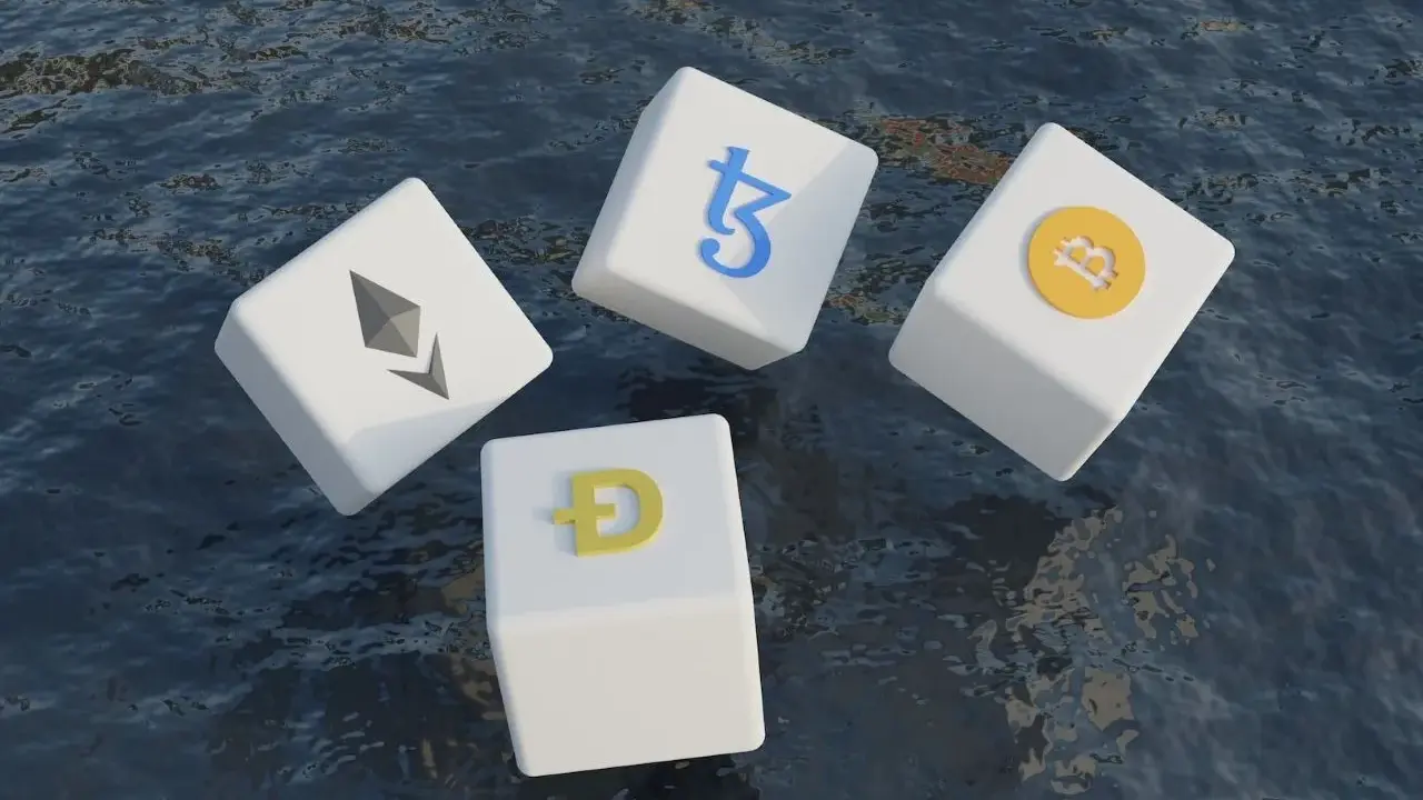 Kostki z symbolami kryptowalut (Bitcoin, Ethereum, Dogecoin, Tezos) unoszą się na wodzie, symbolizując zmienność i potencjał technologii block chain.