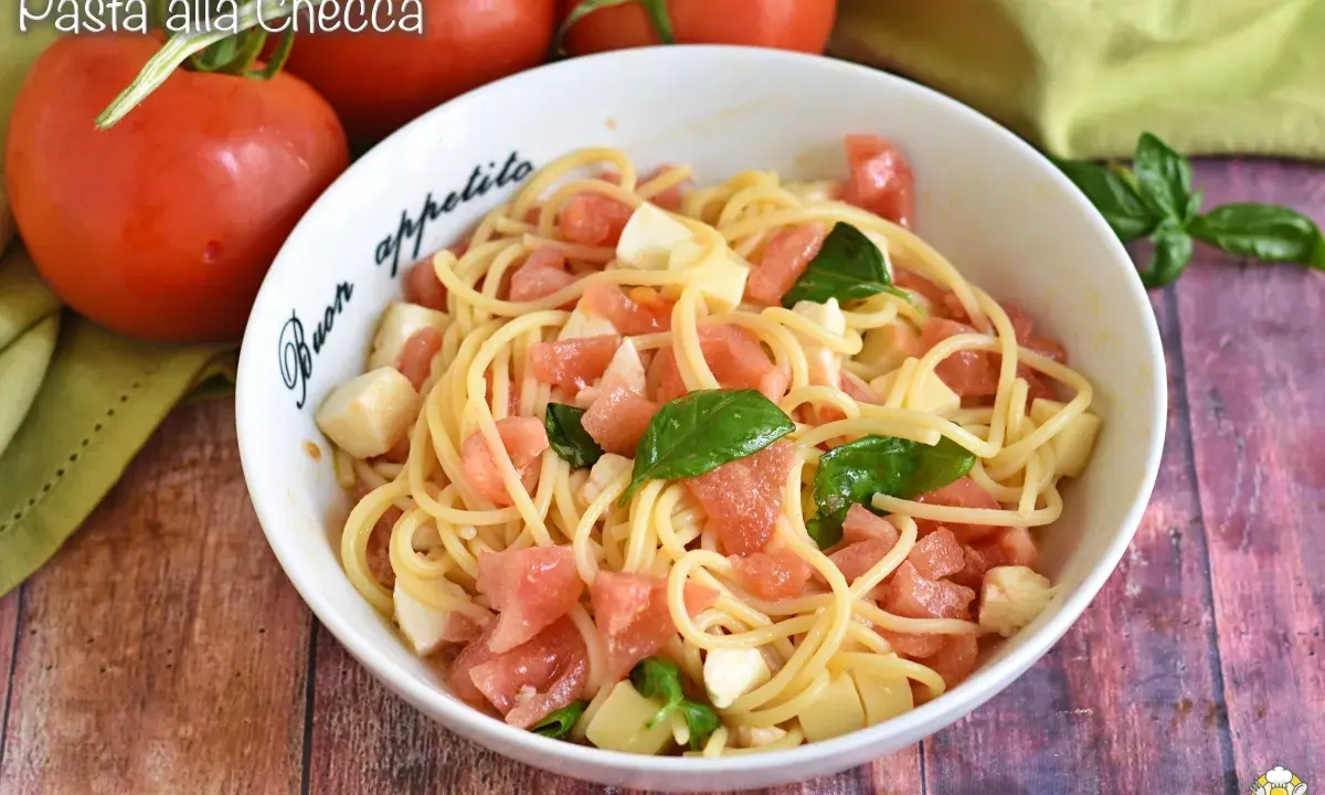 Spaghetti freschi con pomodorini, mozzarella e basilico, un piatto estivo perfetto: pasta alla checca.