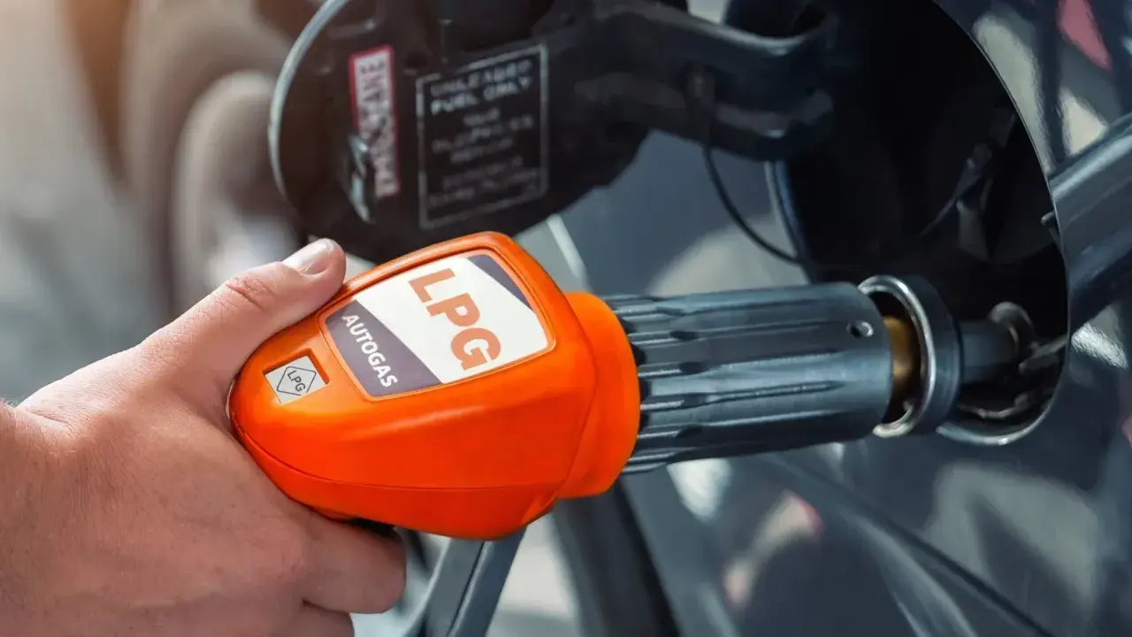 Tankowanie auta gazem LPG. Pomarańczowa końcówka dystrybutora z napisem "AUTOGAS LPG" jest wkładana do baku pojazdu.