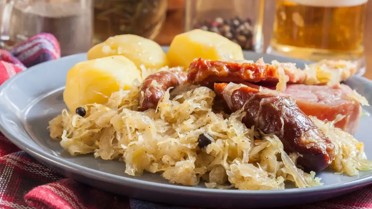 Assiette de choucroute garnie avec pommes de terre, saucisses et lard. Un plat typique de restaurant.
