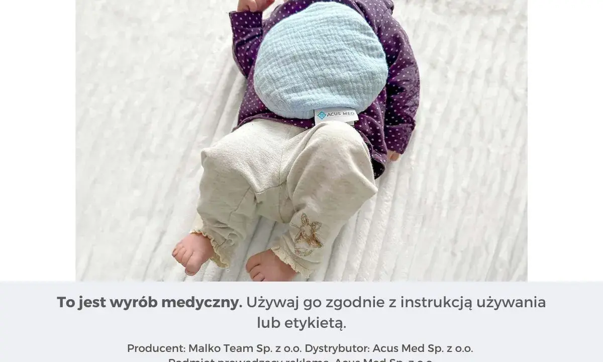 Niemowlę z termoforem z pestek wiśni na brzuszku. Dowiedz się, jak zagrzać taki termofor, by przyniósł ulgę.