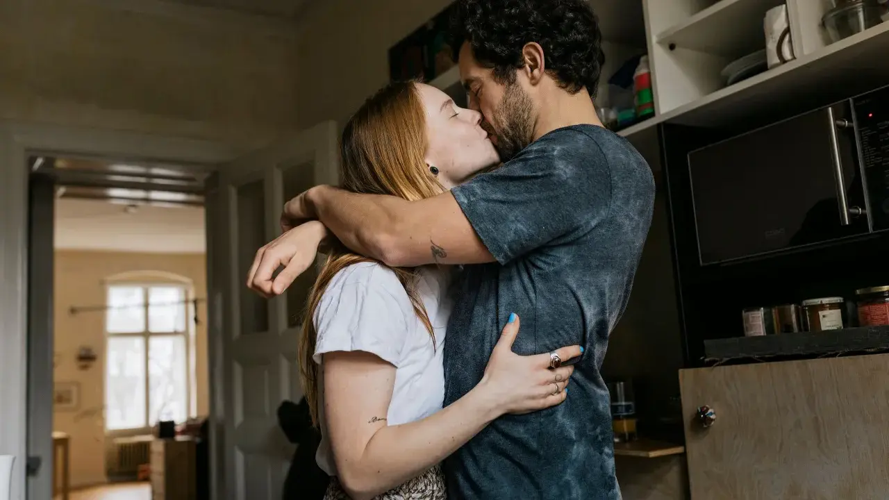 Pareja besándose apasionadamente, sus abrazos y miradas son claras señales no verbales de su amor.