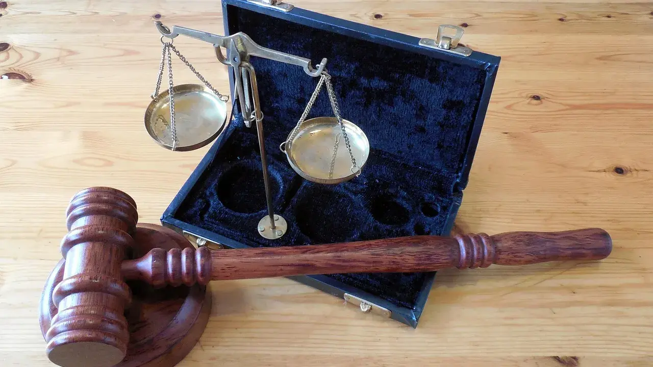 Młotek sędziowski i waga szalkowa w futerale. Symbol sprawiedliwości i prawa, gotowe do wydania wyroku w sprawie 288 kk.