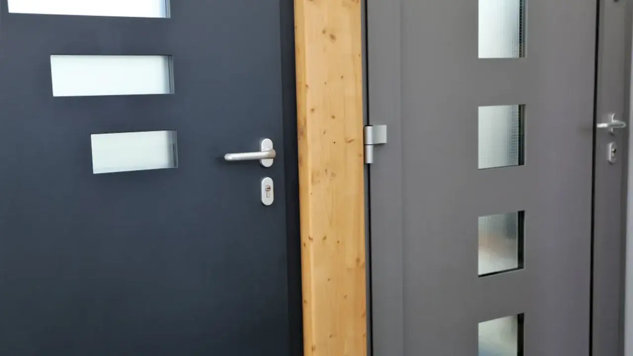 Dwie nowoczesne drzwi wejściowe, jedna ciemnoszara z prostokątnymi przeszkleniami, druga szara z kwadratowymi. Dowiedz się, jak uszczelnić drzwi wejściowe.