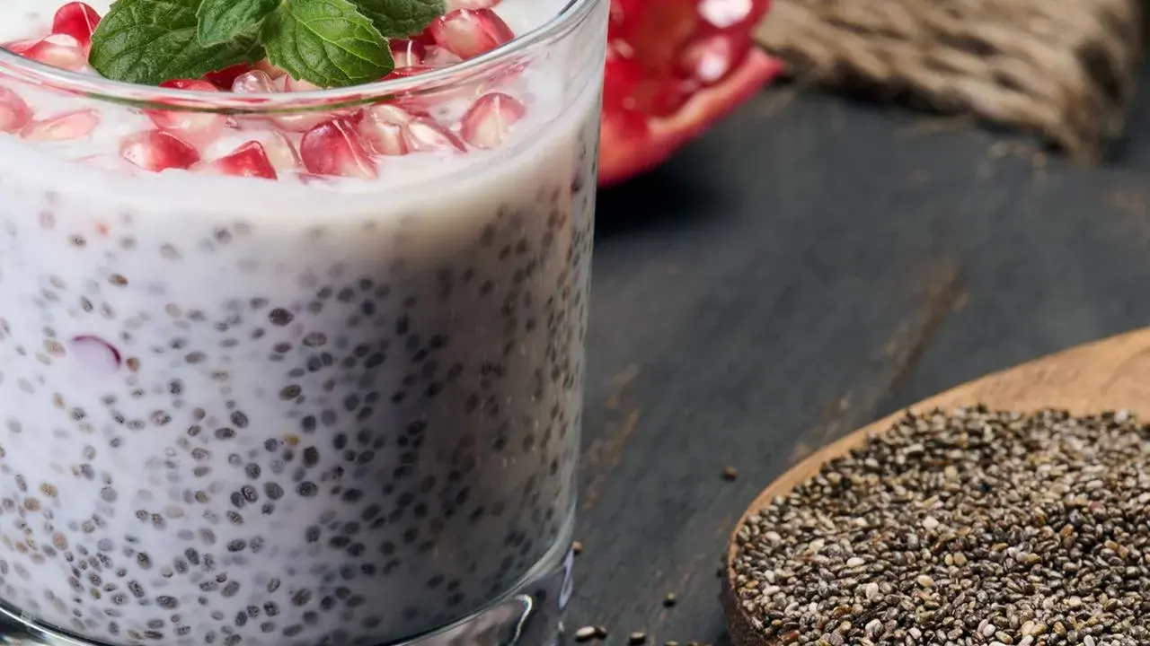 Chia-Samen-Pudding mit Granatapfel und Minze. Bei übermäßigem Verzehr können Chia-Samen Nebenwirkungen haben, auch für die Leber.
