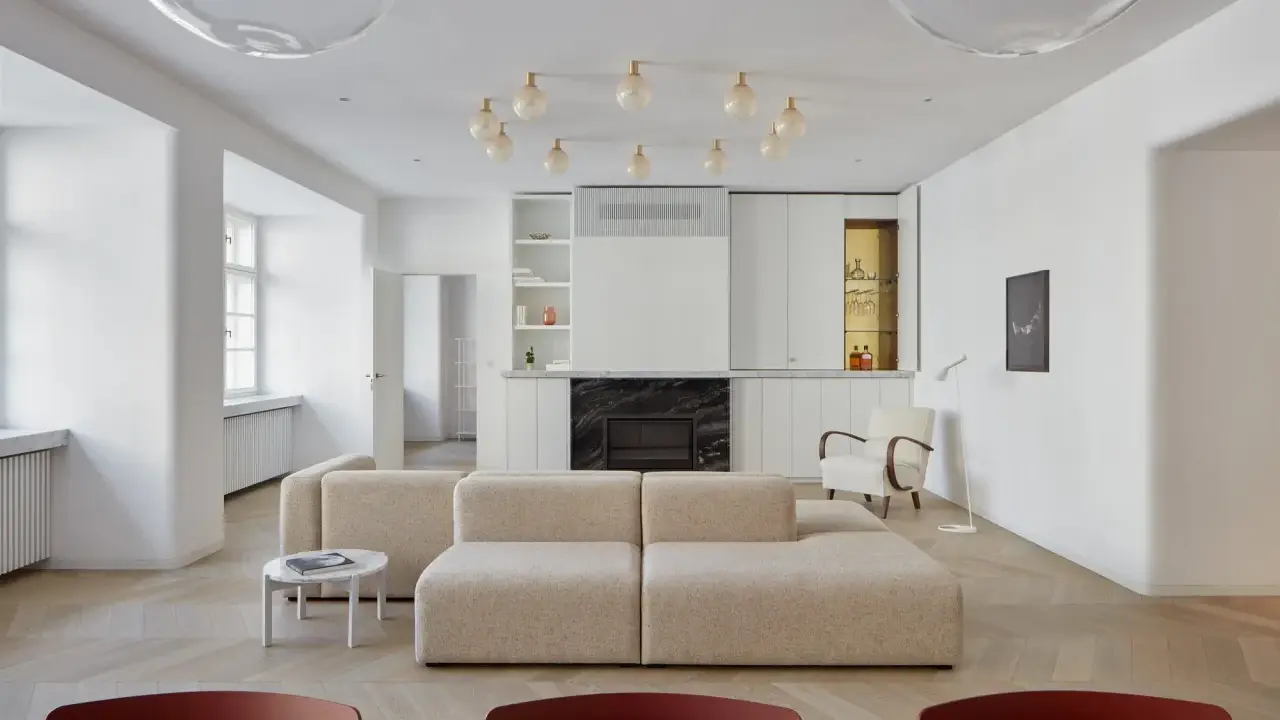 Un moderno sofá en medio del salón, con chimenea y estanterías integradas.