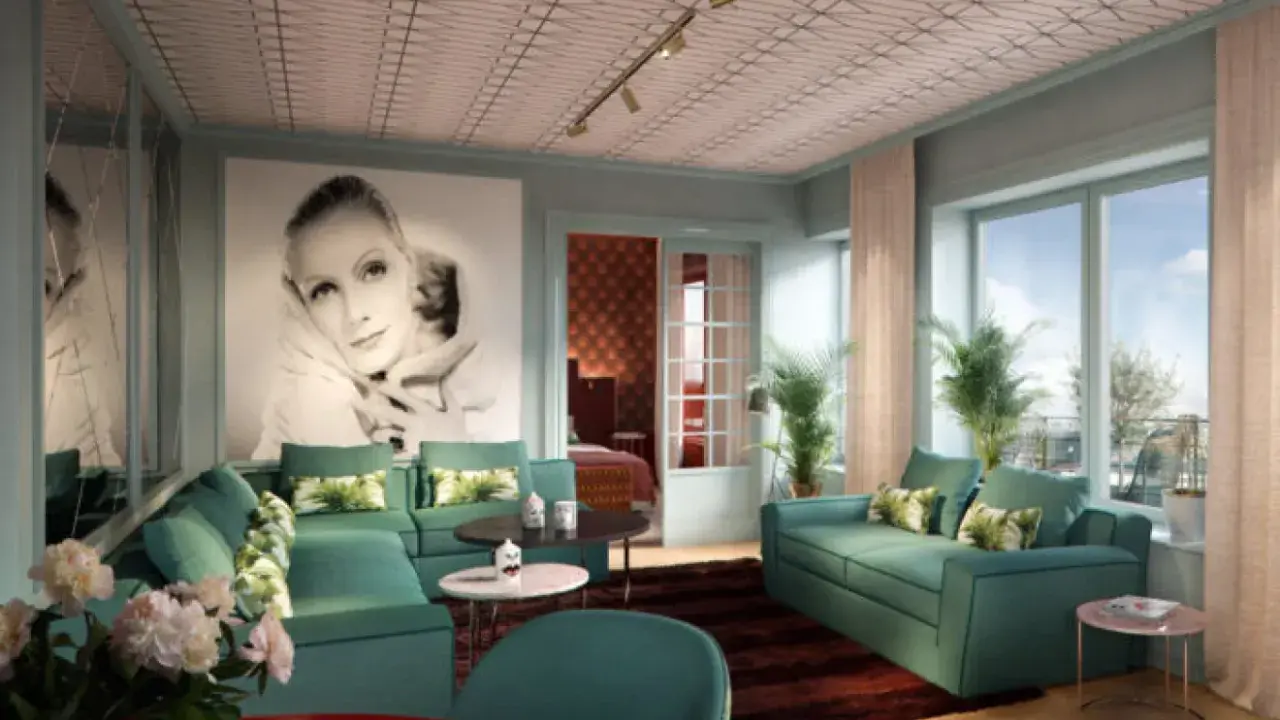 Ett lyxigt vardagsrum med inspiration från art deco i Stockholm. En stor bild av Greta Garbo dominerar väggen, omgiven av turkosa soffor och spegelväggar.