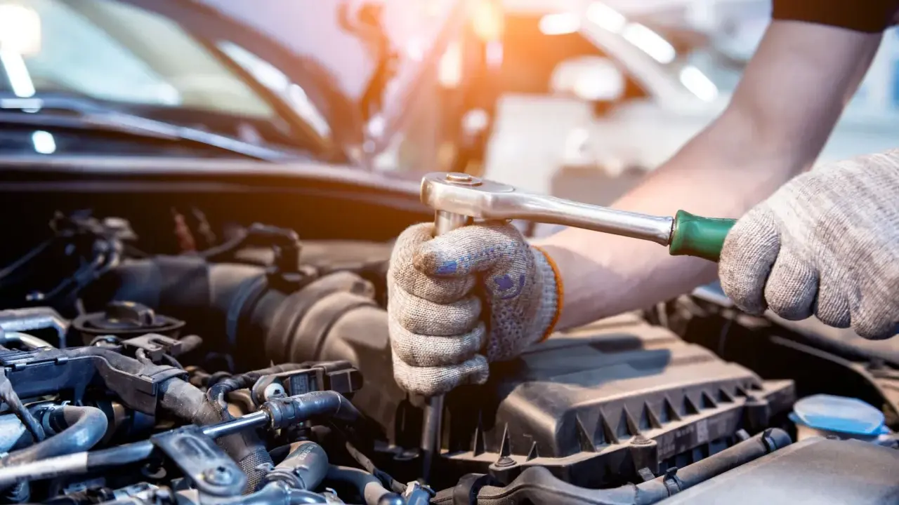 Mecánico revisa el motor de un coche. Aprende como saber si un motor esta quemado observando los componentes.