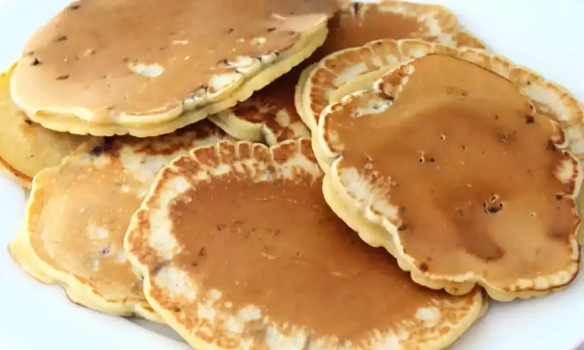Pile de pancakes dorés aux pépites de chocolat, parfaits pour une recette gourmande.