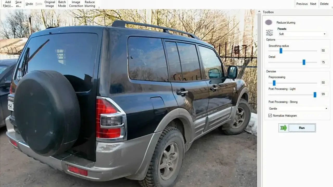 Software per correggere foto mosse. L'immagine mostra un SUV nero con una ruota di scorta sul retro, pronto per essere elaborato.
