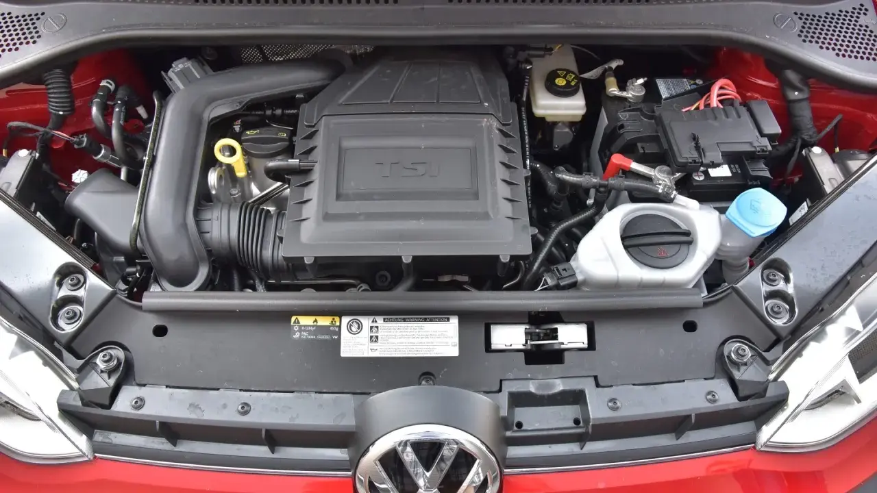 Silnik 1.0 TSI w czerwonym samochodzie, z widocznym logo VW.