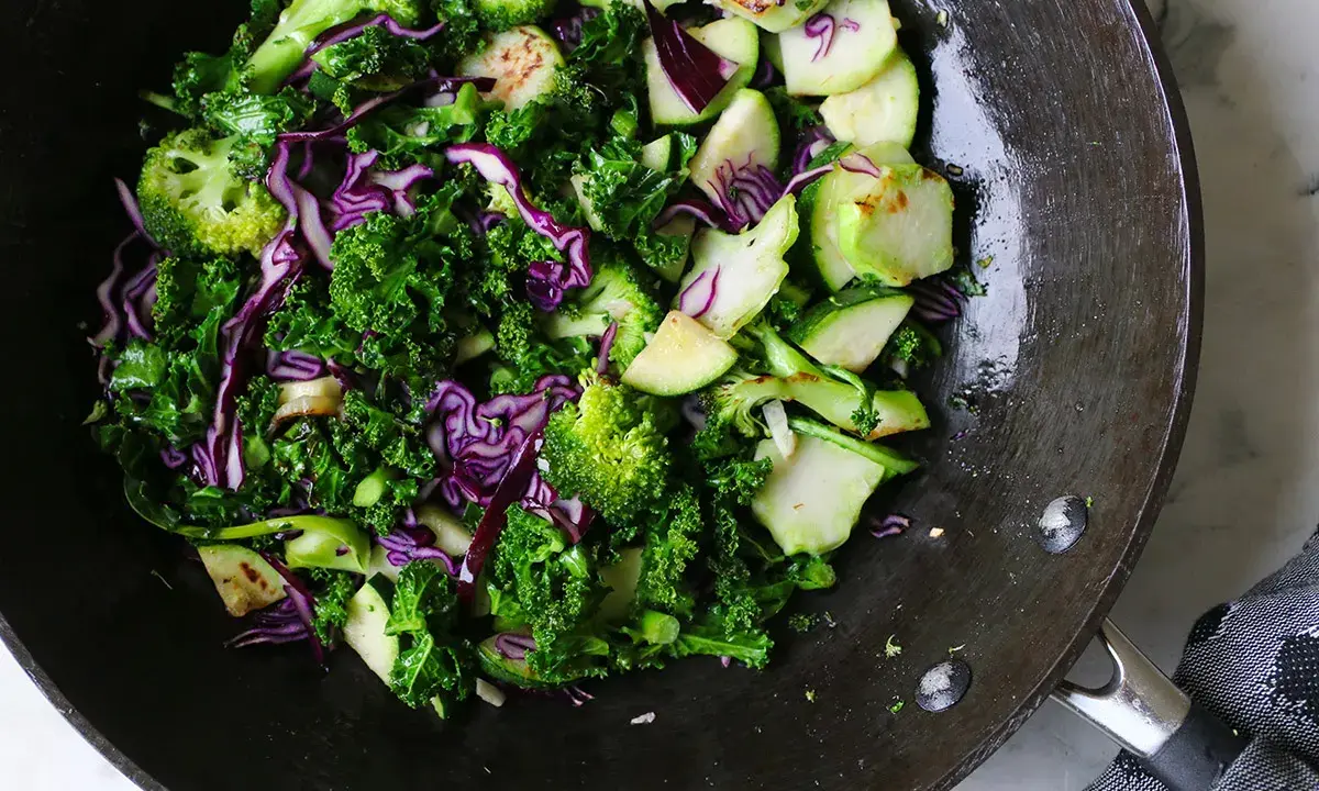 Grönkål, broccoli och rödkål i en wok. Ett härligt sallad recept för en hälsosam måltid.