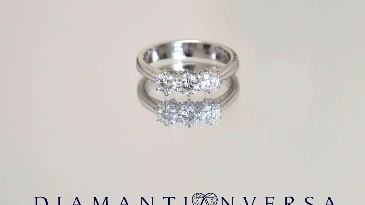 Un anello prezioso con tre diamanti scintillanti, riflesso su una superficie lucida.