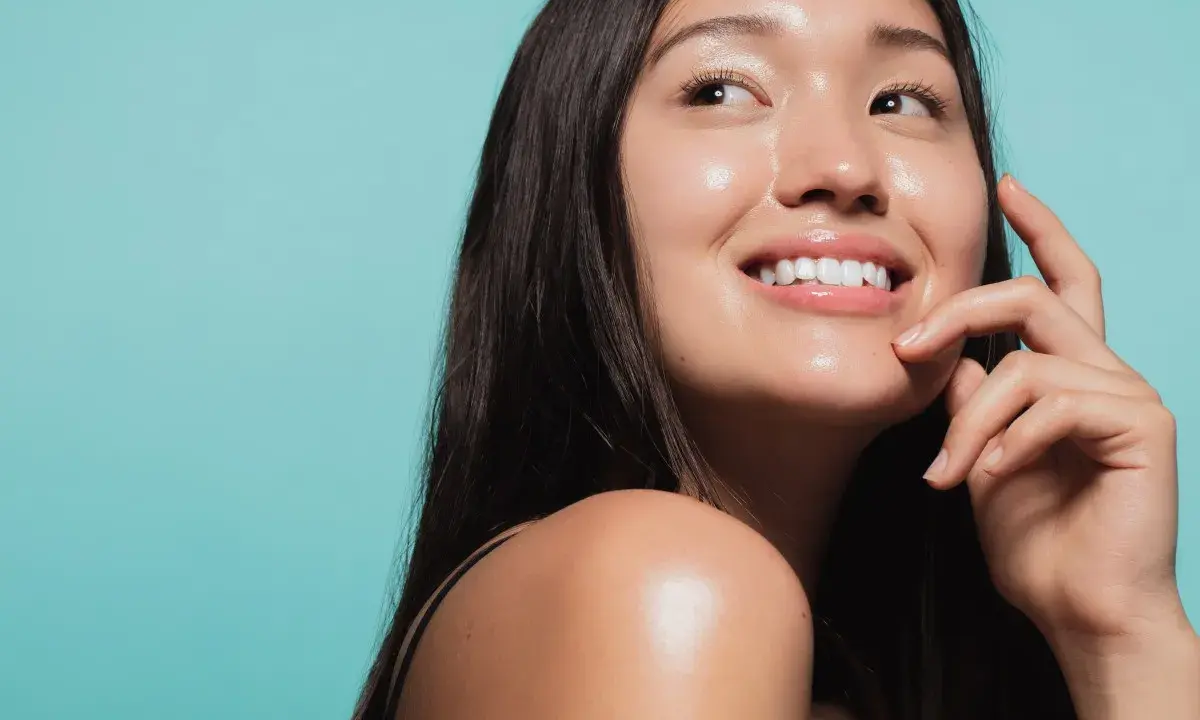 Donna sorridente con pelle luminosa e idratata, un esempio di come idratare la pelle senza creme.